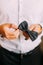 Close-up photo of man in tux holding his bowtie, two hands, no jacket