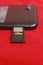Close Up Photo Micro SD Card Memory in Slot at Smartphone at Red Background