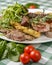 Close-up photo of mixed grilled meat platter. Beef, pork, poultry, sausages, grilled garlic