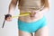 Close up photo of model girl measure her waist with measuring tape in blue pants close up photo