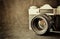 Close up photo of old camera lens over wooden table. image is retro filtered. selective focus