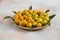Close up photo, Pile of kumquats on wooden plate over colorful background