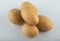 Close up photo of pile of potatoes on white background