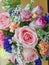 Close-up photo of pink flower bouquet on a wooden board. The colorful bouquet has many kinds of flowers, roses, Carnation.