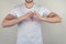 Close up photo portrait of handsome cute nice attractive muscular guy making heart on chest isolated on gray grey background copy