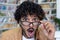 Close-up photo. Portrait of a young hispanic man in a library, bookstore, who looks at the camera in surprise, lowers