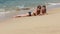 Close up photo of Pretty Caucasian Scandinavian women with teenage son sunbathing at the wet sand close to sea waves, tropical