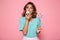 Close-up photo of pretty young girl with magic wand eating delicious cupcake, looking at camera