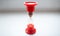 Close-up photo of red hourglass over white background.