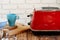 Close up photo of a red toaster on a kitchen table