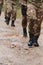 Close up photo, the resilient legs of elite soldiers, clad in camouflage boots, stride purposefully along a hazardous