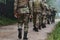 Close up photo, the resilient legs of elite soldiers, clad in camouflage boots, stride purposefully along a hazardous
