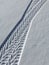 Close-up photo of a road in the winter season. On the snow, a protector is visible