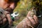 Close-up photo - a sapper clears a booby trap. The wire cutters cutting the wire of the frag grenade trap.