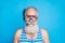 Close up photo of serious pensioner breathe underwater wearing striped swim wear  over blue background