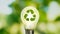 Close up photo of shining lightbulb with nature background as a symbol of reduce energy consumption.