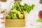 A close-up photo of a still-green tomato .Wooden crate with green tomatoes inside