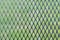 Close-up photo of a structure of iron mesh with green lawn in th