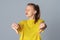 Close up photo of teen girl feeling displeased, showing thumbs down, isolated on light gray background