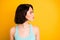 Close up photo of turned girlfriend pondering over someone standing away from her while isolated with yellow background