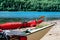 Close up photo of two kayaks stranded on the small Island`s beach. Red life jackets and a paddle, grass strows at the right