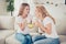 Close up photo two people mom and teenager daughter communicating buddies hold hot beverage sweets hands arms tell speak