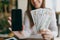 Close up photo of woman in coffee shop at table with bundle of dollars, cash money, mobile phone with blank empty screen