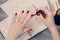 Close up photo of woman`s hands painting fingernails at workplac