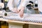 Close-up photo of women`s hands of dressmaker working with sewing patterns. Tailor at work, drawing line on fabric with