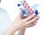 Close up photo of a young female hands holding a small shopping cart full of pills, tablets, capsules and medicine