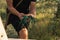 Close up photo of young gardener in black t-shirt that holding green rubber garters in his hands