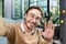 Close-up photo. Young male blogger, student, businessman waving, greeting and talking to camera. Sitting at the desk in