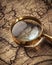 A close-up photograph of a classic magnifying glass hovering over the intricate details of an antique map