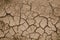 Close-up photograph of cracked earth underfoot. Natural Wallpaper, Texture, Pattern, Background.