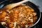 Close-up photograph of a pan cooking a rice and chicken paella in Spain during confinement