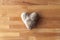 A close up photograph of a raw uncooked heart shaped white potato on a wooden cutting board making a great Valentine`s Day or