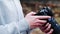 Close-up of a photographer\\\'s hands with a camera. Photographer checking a digital SLR camera on the street