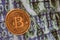 Close up physical bitcoin coin with dollars and matrix codes background