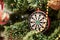 Close up picture of christmas ornaments on green artificial Xmas tree. Red and golden glass darts bauble, bead garland hanging on