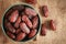 Close up picture of dates palm fruit in cup on sackcloth, wooden table background. Dates palm fruit dry is snack healthy