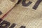 Close up picture of folded empty old burlap with big printed unrecognisible letters. Ecological, natural fabric packing issue, rus