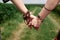 Close-up picture of hands with colorful bracelets and various rings, holding each other. Hippie women, wearing boho style clothes