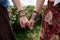 Close-up picture of hands with colorful bracelets and various rings, holding each other. Hippie women, wearing boho style clothes