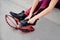 Close-up picture of hands in the process of buttoning kangoo jumps. Young woman`s legs, wearing magenta leggings, putting on