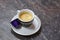 Close up picture of little cup and saucer, with coffee espresso, with tiger pattern design, on marble background. Violet replaceab