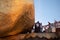 Close up picture of men sticking gold leafs to Kyaiktiyo Pagoda - Golden rock. Guard watching rock. Sacred buddhist pilgrimage