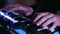 Close-up picture of music artists hands playing on electronic keyboard and pressing pads on a control desk.