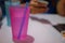 A close-up picture of a pink plastic cup with a plastic tube