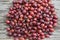 Close up picture of red riped gooseberries on the vintage wooden table