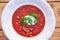Close up picture of the rustic style deep plate full of borsch soup.